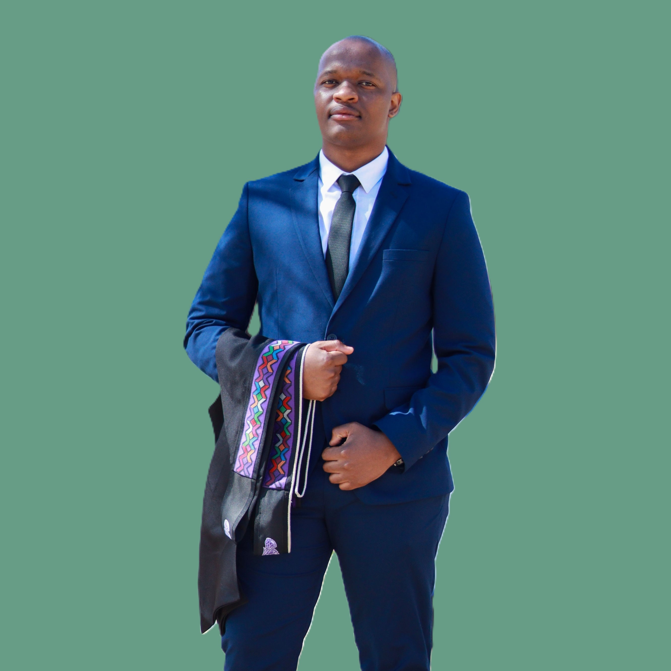Mduduzi Gwija in a navy suit holding his graduation gown and sash